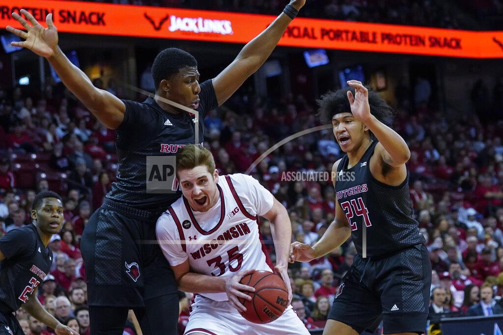 Andy Manis Rutgers' Myles Johnson (15) battles against Rutgers' Shaq Carter, left, and Ron Harper (24) during the second half of an NCAA college basketball game Sunday, Feb. 23, 2020, in Madison, Wis. Wisconsin won 79-71. (AP Photo/Andy Manis)