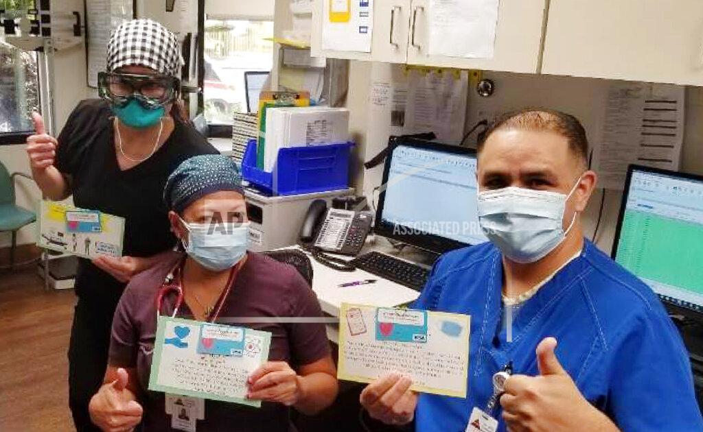Keith Levy In this June 30, 2020, photo provided by Keith Levy, health care workers hold thank-you cards at Los Angeles Community Hospital in Los Angeles. Siblings Mantej Singh Lamba, 17, and Prabhleen Singh Lamba, 15, started the Cards 4 Covid Heroes initiative in May and have since delivered more than 250 cards to hospitals in California and Arizona. (Keith Levy via AP)