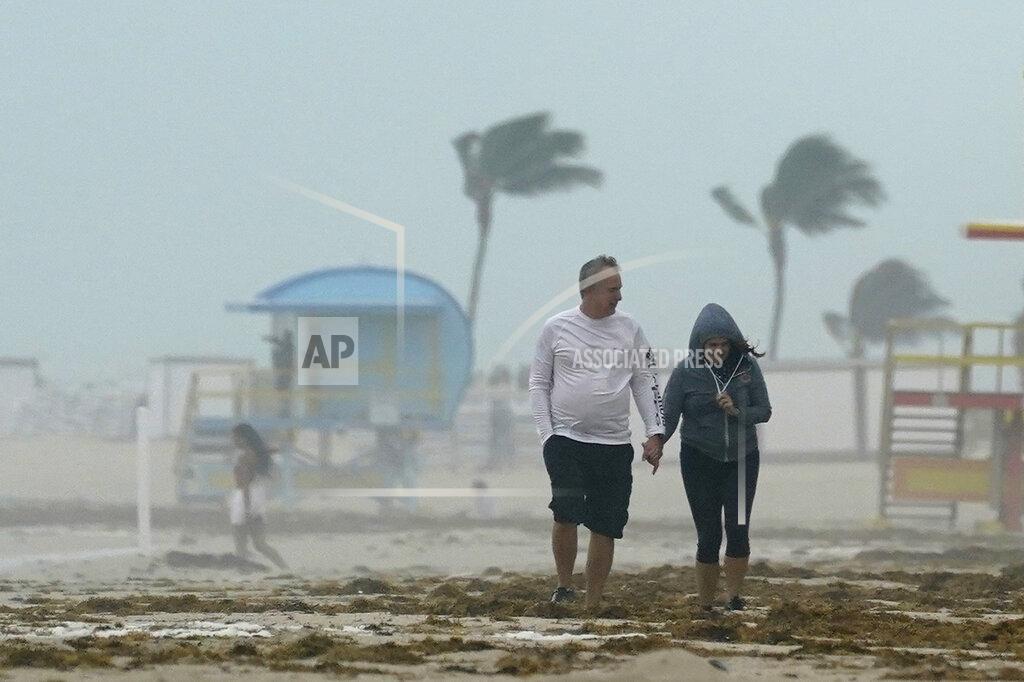 Wilfredo Lee A couple walks along the beach during a downpour, Sunday, Nov. 8, 2020, on Miami Beach, Florida's famed South Beach. A strengthening Tropical Storm Eta cut across Cuba on Sunday, and forecasters say it's likely to be a hurricane before hitting the Florida Keys Sunday night or Monday. (AP Photo/Wilfredo Lee)