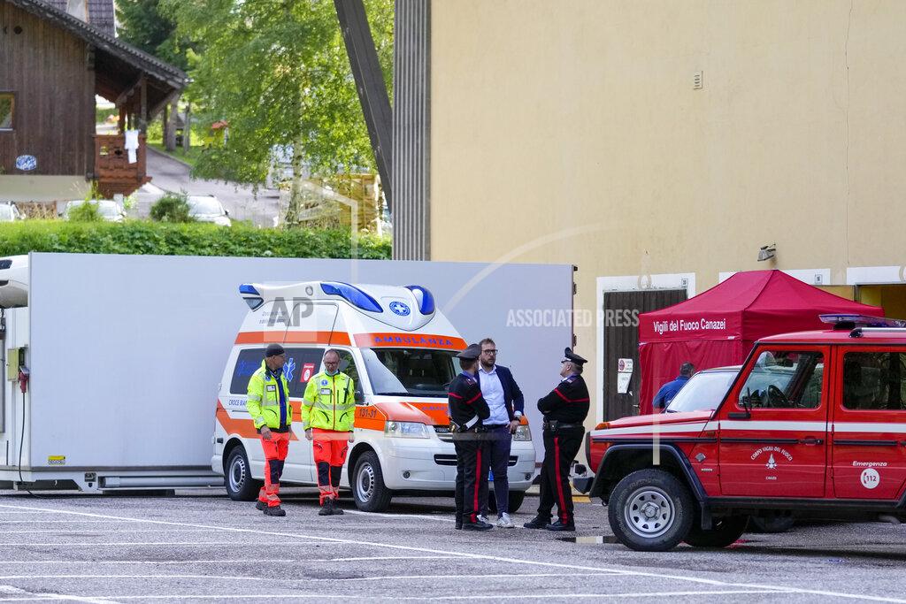 Luca Bruno Carabinieri police officers and rescuers stand by the refrigerated container where the bodies of the people who died under the Punta Rocca glacier avalanche are kept in Canazei, in the Italian Alps in northern Italy, Monday, July 4, 2022, a day after a huge chunk of the glacier broke loose, sending an avalanche of ice, snow, and rocks onto hikers. Rescuers said conditions downslope from the glacier, which has been melting for decades, were still too unstable to immediately send rescuers and dogs into the area to look for others buried under tons of debris. (AP Photo/Luca Bruno)