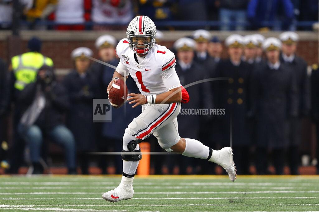 Paul Sancya Ohio State quarterback Justin Fields rolls out to pass against Michigan in the second half of an NCAA college football game in Ann Arbor, Mich., Saturday, Nov. 30, 2019. (AP Photo/Paul Sancya)