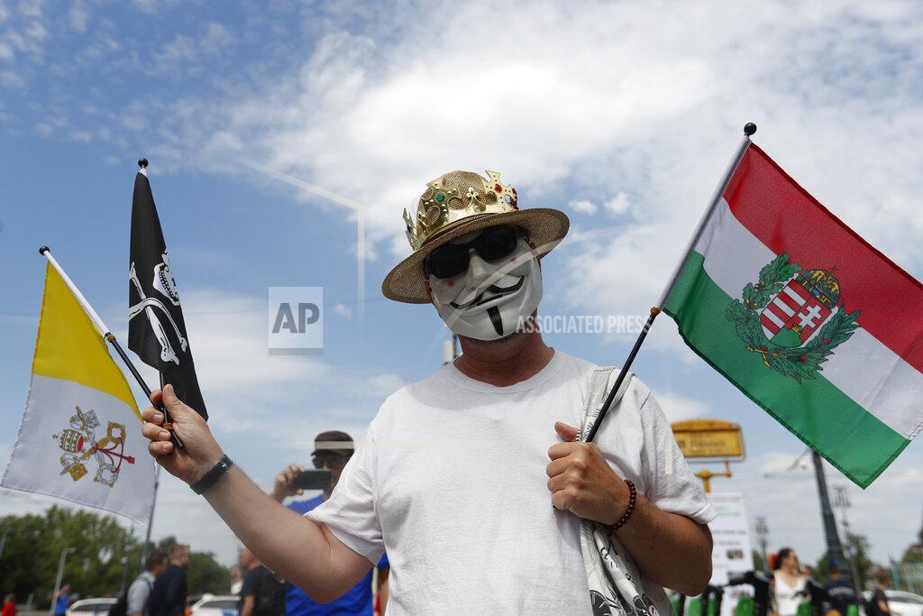 Laszlo Balogh A protester holds Vatican's and Hungarian flags during a rally in Budapest, Hungary, Saturday, June 5, 2021. Thousands of people gathered opposing the Hungarian government's plan of building a campus for China's Fudan University in Budapest. (AP Photo/Laszlo Balogh)