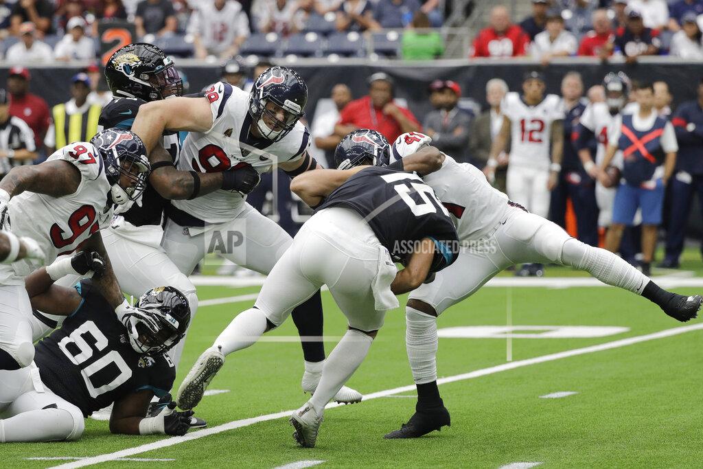 David J. Phillip Jacksonville Jaguars quarterback Gardner Minshew (15) is sacked by Houston Texans defenders Angelo Blackson (97), J.J. Watt (99) and Zach Cunningham (41) during the first half of an NFL football game Sunday, Sept. 15, 2019, in Houston. (AP Photo/David J. Phillip)