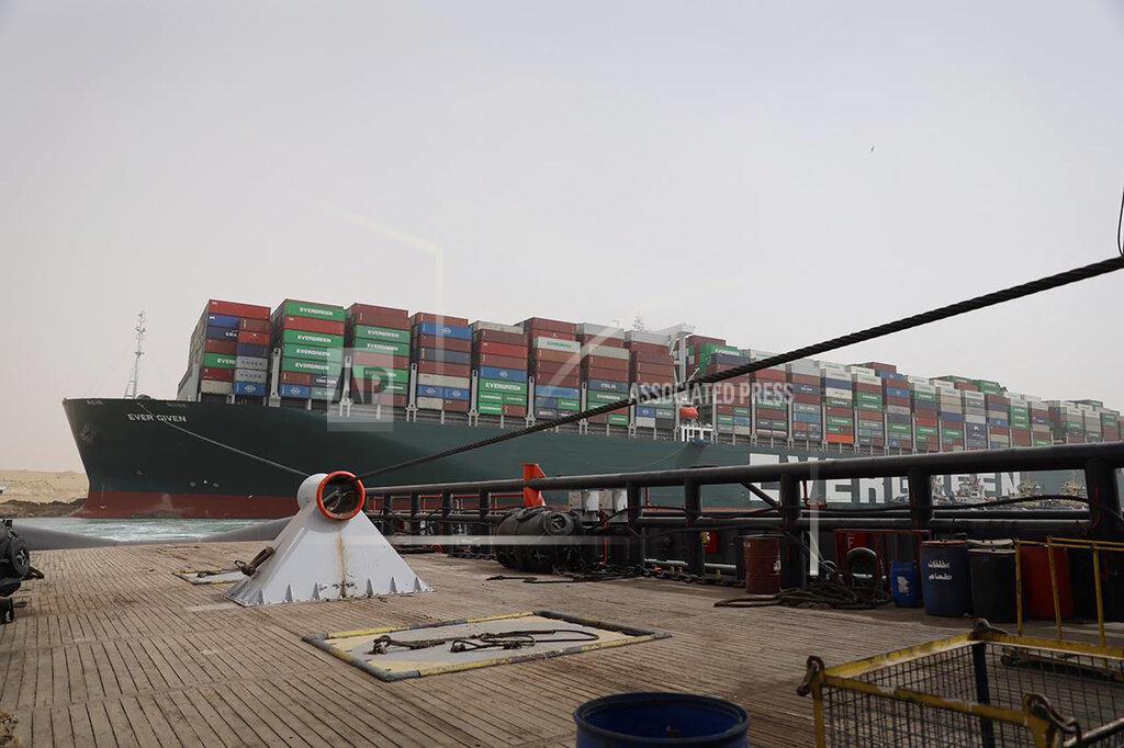 Uncredited This photo released by the Suez Canal Authority on Thursday, March 25, 2021, shows the Ever Given, a Panama-flagged cargo ship, after it become wedged across the Suez Canal and blocking traffic in the vital waterway from another vessel. An operation is underway to try to work free the ship, which further imperiled global shipping Thursday as at least 150 other vessels needing to pass through the crucial waterway idled waiting for the obstruction to clear. (Suez Canal Authority via AP)