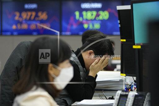 A currency trader covers his face with his hands at the foreign exchange dealing room of the KEB Hana Bank headquarters in Seoul, South Korea, Thursday, Jan. 13, 2022. Shares were mostly lower in Asia on Wednesday after the latest report of surging prices in the U.S. appeared to keep the Federal Reserve on track to raise interest rates in coming months.(AP Photo/Ahn Young-joon)