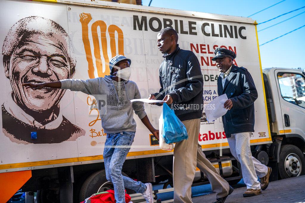 Jerome Delay A volunteer directs two men towards a medical tent where they will be tested for COVID-19 as well as HIV and Tuberculosis, in downtown Johannesburg Thursday, April 30, 2020. Thousands are being tested in an effort to derail the spread of coronavirus. South Africa will began a phased easing of its strict lockdown measures on May 1, although its confirmed cases of coronavirus continue to increase. (AP Photo/Jerome Delay)