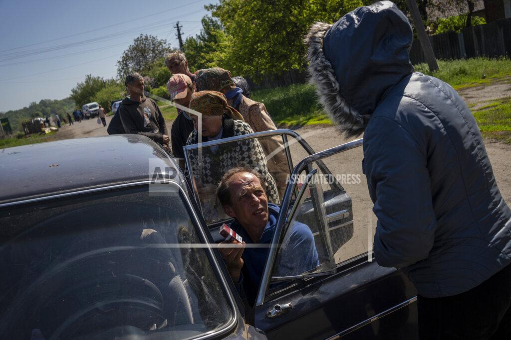 Bernat Armangue Villagers queue to buy cigarettes and bread from a peddler in the village of Staryi Saltiv, east Kharkiv, Ukraine, Friday, May 20, 2022. The village formerly occupied by Russian forces is back under Ukrainian control, albeit very close to the front line and under constant shelling. (AP Photo/Bernat Armangue)