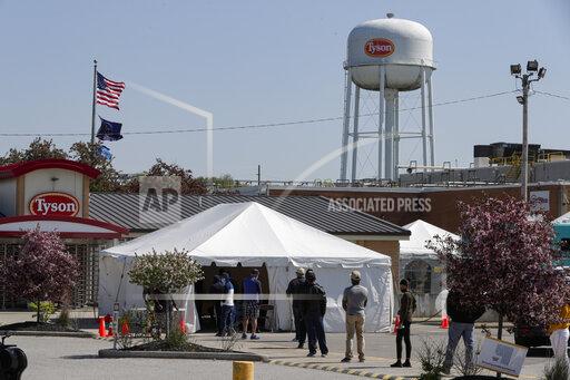FILE - In this May 7, 2020, file photo workers wait in line to enter the Tyson Foods pork processing plant in Logansport, Ind. At least 59,000 meatpacking workers became ill with COVID-19 and 269 workers died when the virus tore through the industry last year, which is significantly more than previously thought, according to a new U.S. House report released Wednesday, Oct. 27, 2021. (AP Photo/Michael Conroy, File)