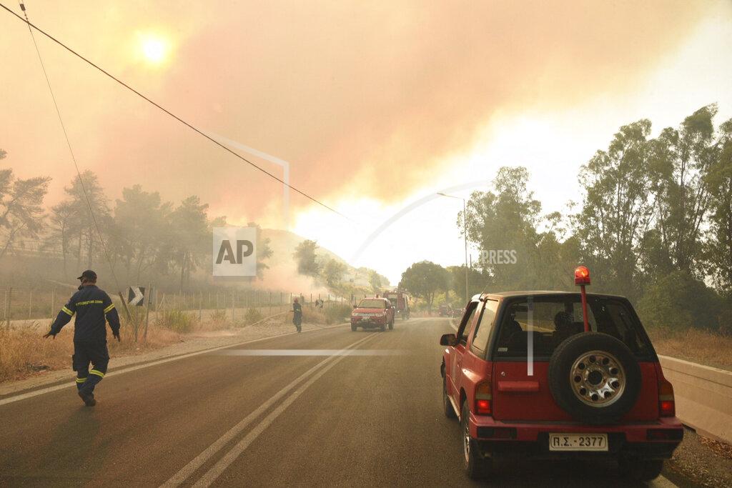 Andreas Alexopoulos Firefighters operate during a wildfire near Lampiri village, west of Patras, Greece, Saturday, Jul. 31, 2021. The fire, which started high up on a mountain slope, has moved dangerously close to seaside towns and the Fire Service has send a boat to help in a possible evacuation of people. (AP Photo/Andreas Alexopoulos)
