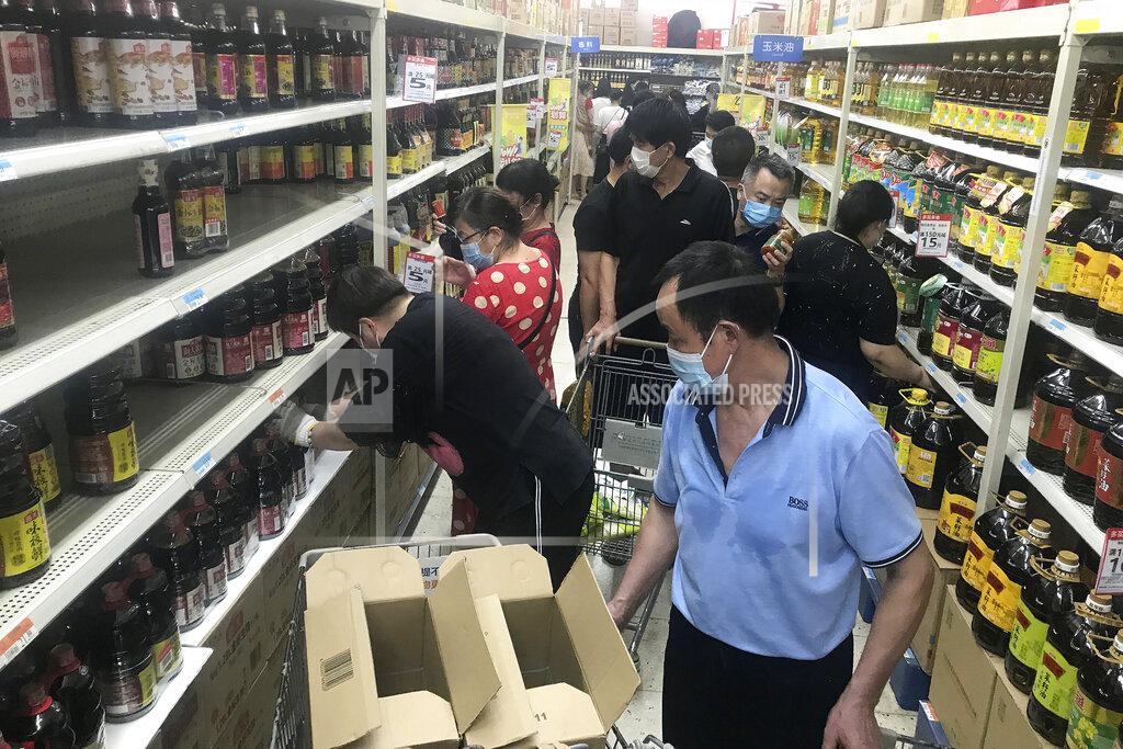 Uncredited Residents rush to stock up on necessities at a supermarket after authorities lockdown near residential blocks to prevent the spread of the COVID-19 in Wuhan city in central China's Hubei province Monday, Aug. 2, 2021. Chinese authorities announced Tuesday the mass testing of Wuhan as an unusually wide series of COVID-19 outbreaks reached the city where the disease was first detected in late 2019. (Chinatopix via AP)