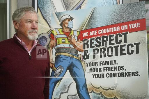 Rob Moore is the CEO of Salt Lake City-based Big-D Construction poses for a photograph Monday, Oct. 11, 2021, in Salt Lake City. Moore said he supports vaccines but has questions about the mandate rollout. He already has a worker shortage on his job sites, and he said employee surveys tell him that nearly 20% of his workers don't want to get inoculated, so they would need to be tested weekly. (AP Photo/Rick Bowmer)