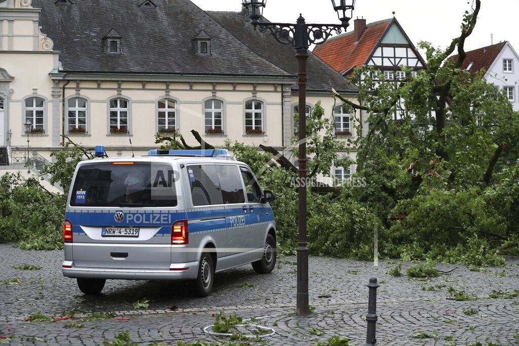 Friso Gentsch A police vehicle stands next to a downed tree from severe weather in Lippstadt, Germany, Friday, May 20, 2022. Meteorologists had warned that heavy rainfall and hail were expected in western and central Germany on Friday, with storms producing wind gusts up to 130 kph (81 mph). (Friso Gentsch/dpa via AP)