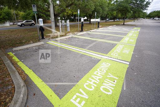 John Raoux A parking area with charging stations for electric vehicles at a public park is seen Thursday, April 1, 2021, in Orlando, Fla. As part of an infrastructure proposal by the Biden administration, $174 billion will be set aside to build 500,000 electric vehicle charging stations, electrify 20% of school buses and electrify the federal fleet, including U.S. Postal Service vehicles.(AP Photo/John Raoux)