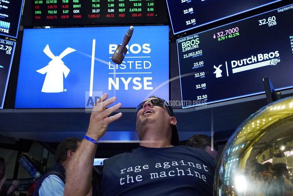 Richard Drew CORRECTS TITLE TO EXECUTIVE CHAIRMAN, NOT PRESIDENT - Dutch Bros Coffee Co-founder and Executive Chairman Travis Boersma tosses the gavel after he rang the ceremonial first trade bell on the floor of the New York Stock Exchange, as his company's IPO opens, Wednesday, Sept. 15, 2021. (AP Photo/Richard Drew)