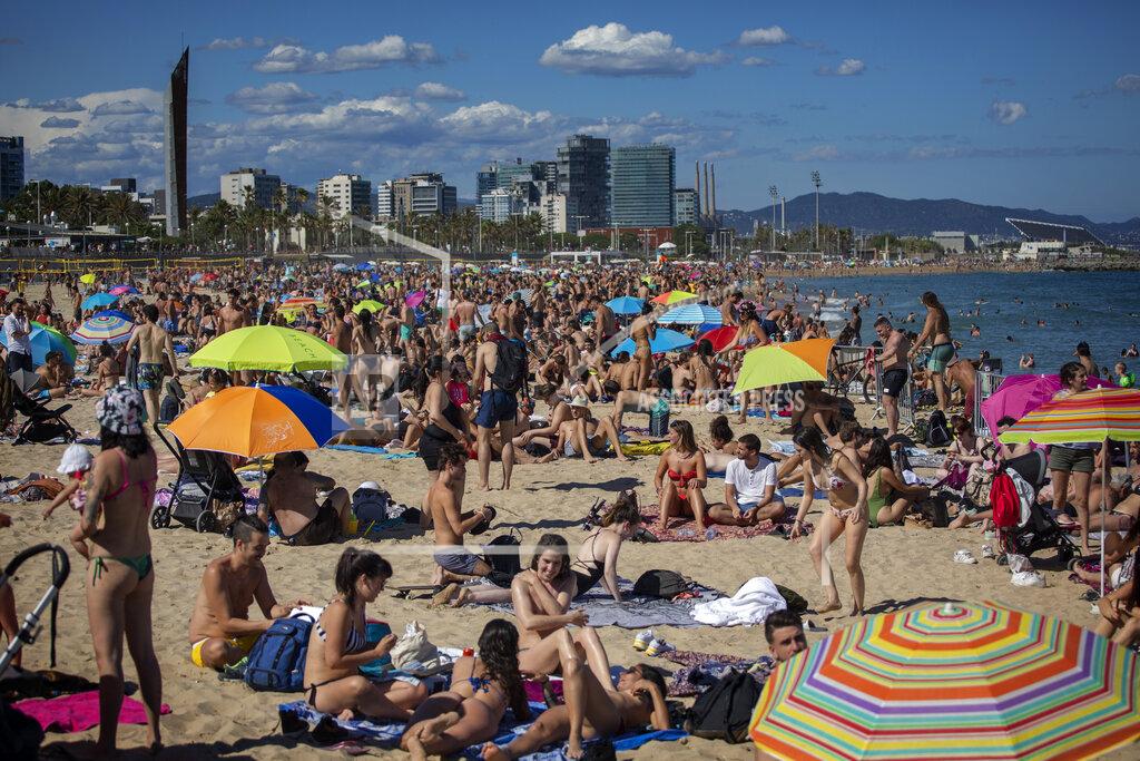 Emilio Morenatti People enjoy the warm weather on the beach in Barcelona, Spain, Saturday, June 13, 2020. Spanish government has announced that the northwestern region of Galicia will move next week to what the government calls "the new normal," when some rules, such as wearing face masks when social distancing is not possible, will remain in place. (AP Photo/Emilio Morenatti)
