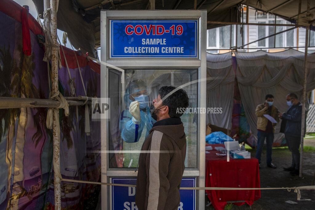 Dar Yasin A health worker takes a nasal swab sample of a Kashmiri to test for COVID-19 in Srinagar, Indian-controlled Kashmir, Tuesday, March 30, 2021. More than 50,000 people tested positive for COVID-19 in the last 24 hours, taking the total cases across the country to 12 million, according to the Union health ministry on Tuesday. (AP Photo/ Dar Yasin)
