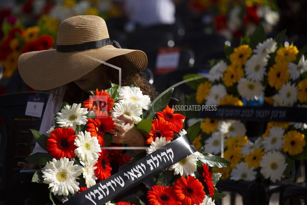 Maya Alleruzzo A woman holds a wreath at a ceremony marking the annual Holocaust Remembrance Day, at Yad Vashem Holocaust Memorial in Jerusalem, Thursday, April 8, 2021. (AP Photo/Maya Alleruzzo, Pool)