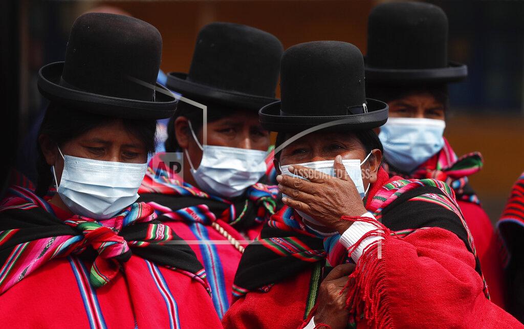 Juan Karita Aymara Indigenous women wearing masks amid the new coronavirus pandemic wait to enter the archaeological museum in Tiwanaku, Bolivia, Tuesday, Jan. 12, 2021. Bolivian archaeologists are presenting the findings of a recent discovery of ancient vessels unearthed in a dig on the site once home to one of the most significant pre-Hispanic empires, the Tiwanacota. (AP Photo/Juan Karita)
