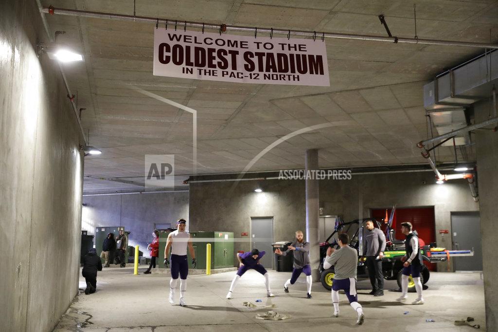 Ted S. Warren Washington players warm up near a sign in the Martin Stadium tunnel that reads "Welcome to the Coldest Stadium in the Pac-12 North," before an NCAA college football game against Washington State, Friday, Nov. 23, 2018, in Pullman, Wash. Game-time temperatures were expected to be in the low 30's. (AP Photo/Ted S. Warren)