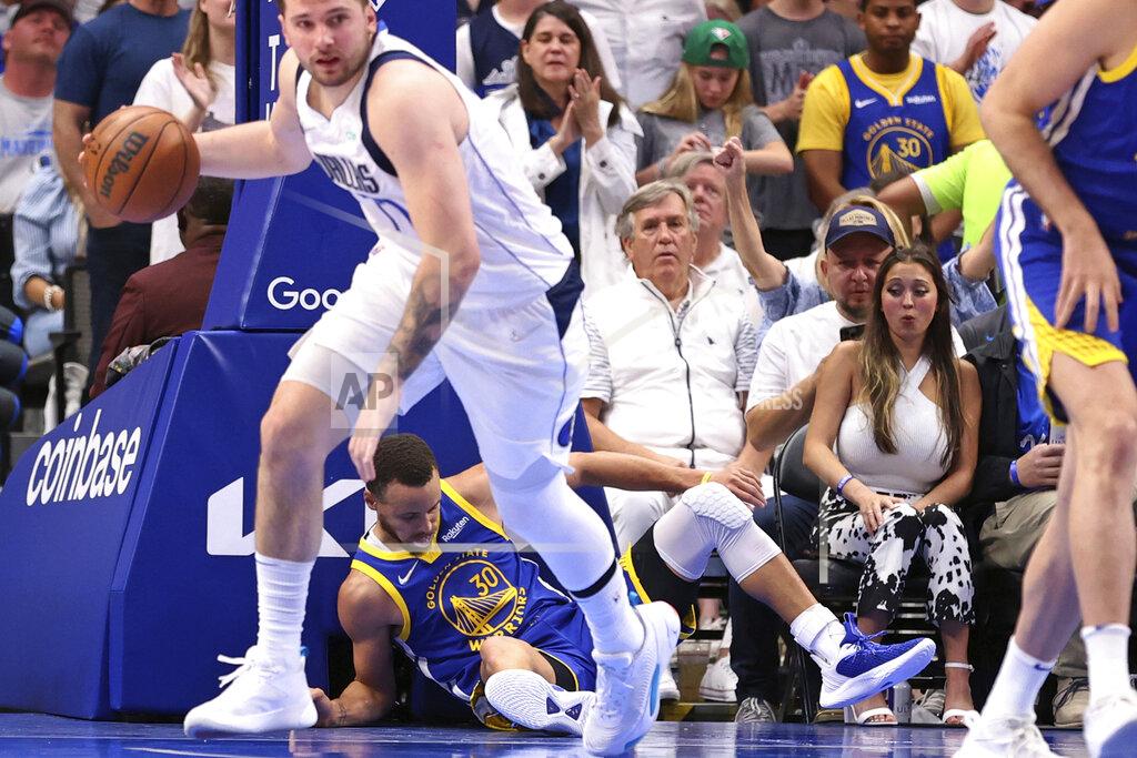 Scott Strazzante Golden State Warriors' Stephen Curry lies on the court as Dallas Mavericks' Luka Doncic dribbles during the third quarter in Game 4 of NBA basketball playoffs Western Conference finals in Dallas on Tuesday, May 24, 2022. (Scott Strazzante/San Francisco Chronicle via AP)
