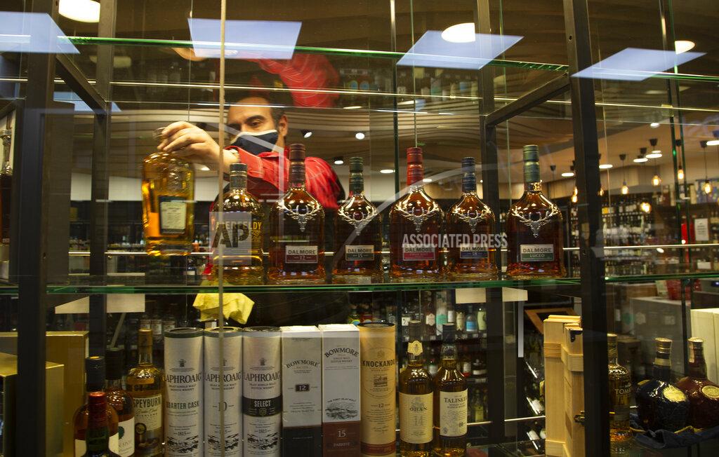 Denis Farrell A man stocks a display shelf with bottles of alcohol at a Johannesburg liquor store in Johannesburg Monday, Aug. 17, 2020 as the country will lift its coronavirus-linked ban on the sale of alcohol and tobacco products on Tuesday. The purchase of alcohol and cigarettes was banned when the country went into a strict nationwide lockdown on 27 March to stem the spread of coronavirus. (AP Photo/Denis Farrell)