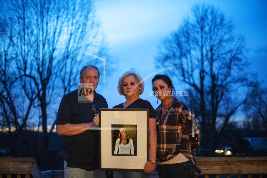 David Goldman Jeff and Lola Carter stand with their daughter, Amanda, and a framed photo of Kayla, their daughter who struggled with drug addiction, Tuesday, March 16, 2021, at their home in Milton, W.Va. Kayla was hospitalized in June with endocarditis, a heart infection common among injection drug users. It seemed like she was suddenly determined to live. In October, her mother couldn't reach her one Friday. She went to her apartment, and found her dead on her bathroom floor. They are still waiting for the medical examiner's report, but her father would rather never see it. It brings him comfort to think she died from a complication from her surgeries, and not that she relapsed and overdosed. Either way, the drugs killed her, he said. "The only thing about any of it gives me any relief at all," he says, "is knowing we're not the only ones." (AP Photo/David Goldman)