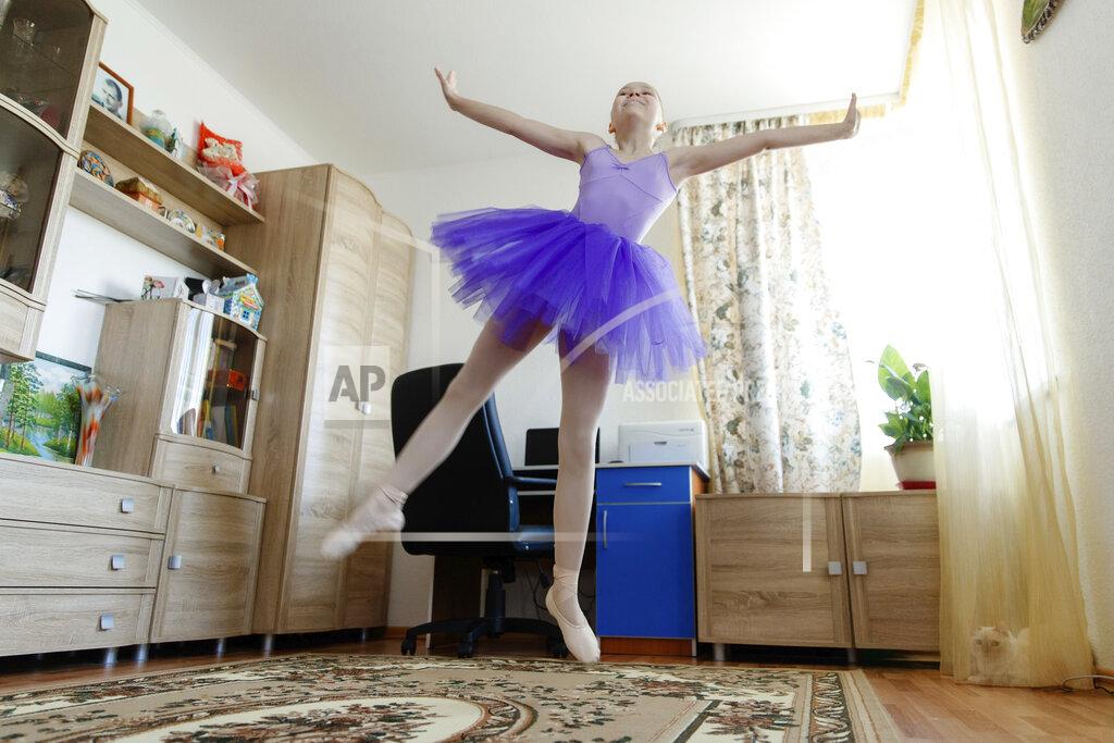Anton Basanaev Alexandra Kustova, shows how she dances prior to an interview in her family's apartment in Yekaterinburg, a city in the Urals, Russia on Thursday, May 7, 2020. For 12-year-old Alexandra, self-isolation during the coronavirus pandemic turned out to be a blessing in disguise. Now that all the studies are conducted online, not only does she have more time for her two favorite hobbies _ ballet and jigsaw puzzles _ she spends more time with her family and helps out her grandmother, who lives in the same building two floors down. (AP Photo/Anton Basanaev)