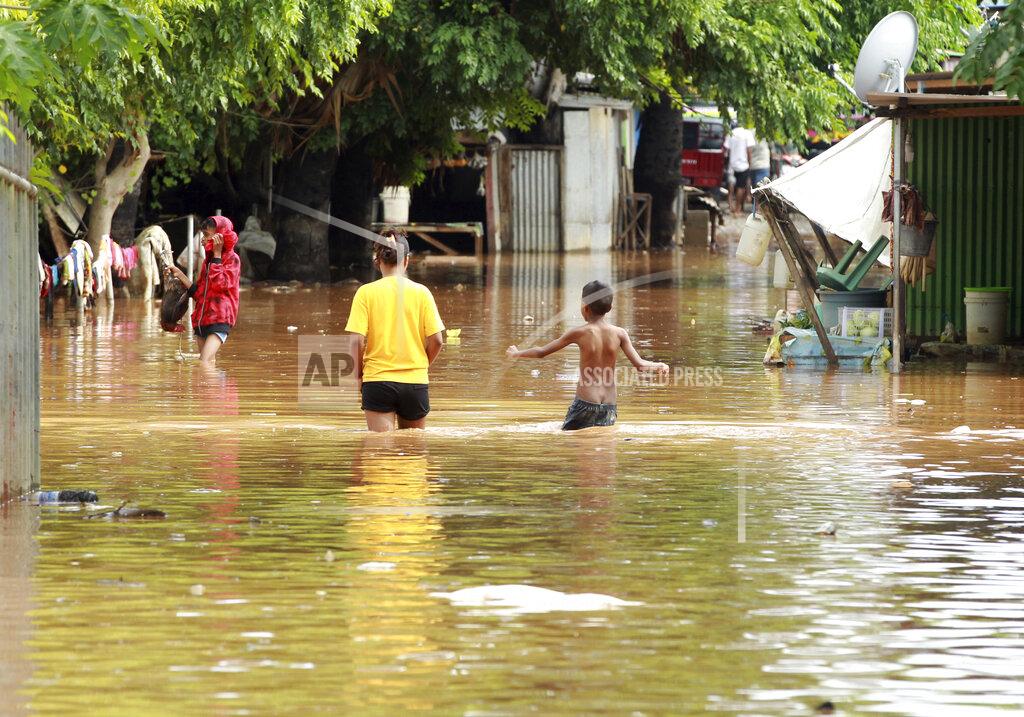 Kandhi Barnez People wade through flood waters in Dili, East Timor, Monday, April 5, 2021. Multiple disasters caused by torrential rains in eastern Indonesia and neighboring East Timor have left dozens of people dead and missing and displaced thousands. (AP Photo/Kandhi Barnez)