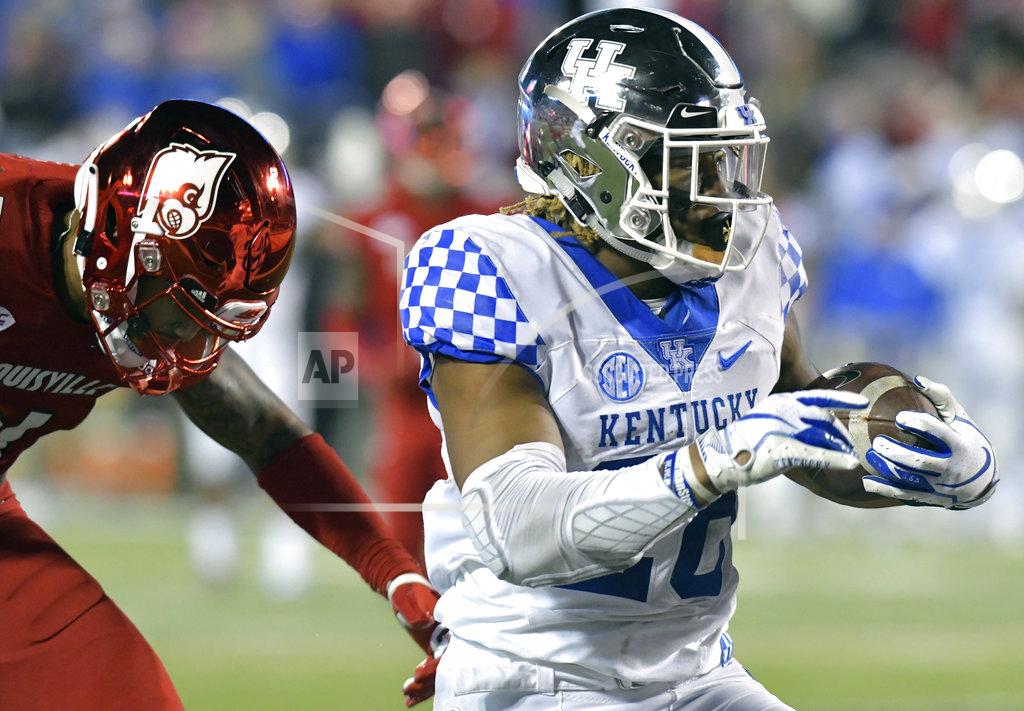 Timothy D. Easley Kentucky running back Benny Snell Jr. (26) runs from the grasp of Louisville safety TreSean Smith (4) as he scores a touchdown during the first half of an NCAA college football game in Louisville, Ky., Saturday, Nov. 24, 2018. (AP Photo/Timothy D. Easley)