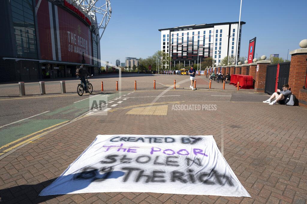 Jon Super Football supporters place a protest banner outside Manchester United's Old Trafford Stadium, Manchester, England, Monday, April 19, 2021, opposing the formation of the European Super League. Players at the 12 clubs setting up their own Super League could be banned from this year’s European Championship and next year’s World Cup, UEFA President Aleksander Ceferin said Monday. (AP Photo/Jon Super)