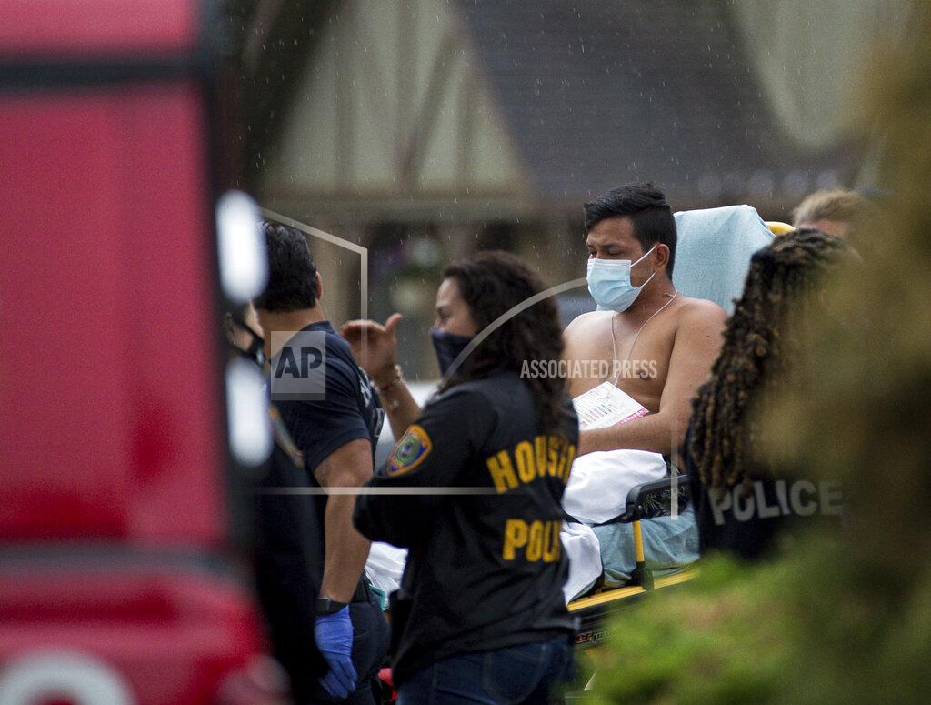 Godofredo A. Vásquez Paramedics transport a man into an ambulance from the scene of a human smuggling case, where more than 90 undocumented immigrants were found inside a home on the 12200 block of Chessington Drive, Friday, April 30, 2021, in Houston. A Houston Police official said the case will be handled by federal authorities and that some of the people inside the house were exhibiting COVID-19 symptoms. ( Godofredo A. Vásquez/Houston Chronicle via AP)