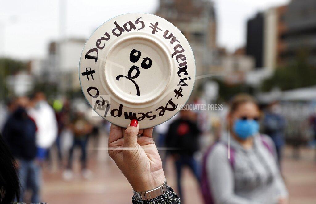 A plate reads in Spanish "Debts. Urgency. Unemployment," as restaurant and bar workers break plates to protest the nighttime lockdown that forces them to close early during the COVID-19 pandemic in Bogota, Colombia, Monday, April 26, 2021. (AP Photo/Fernando Vergara)