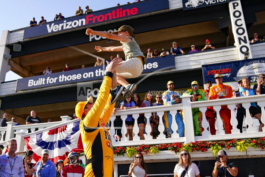Matt Slocum Kyle Busch, left, tosses his six-year-old son Brexton as he celebrates after winning a NASCAR Cup Series auto race at Pocono Raceway, Sunday, June 27, 2021, in Long Pond, Pa. (AP Photo/Matt Slocum)