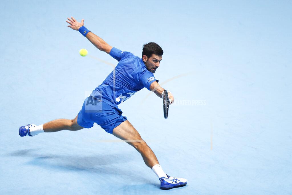 Frank Augstein Novak Djokovic of Serbia returns the ball to Dominic Thiem of Austria during their semifinal match at the ATP World Finals tennis tournament at the O2 arena in London, Saturday, Nov. 21, 2020. (AP Photo/Frank Augstein)