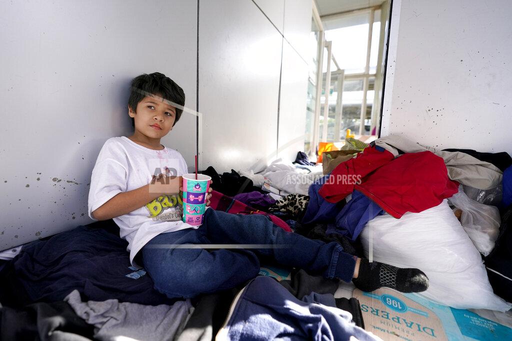 Julio Cortez Miguel David Fajardo, 8, a migrant from Honduras, rests at a plaza near the McAllen-Hidalgo International Bridge point of entry into the United States after he, his 13-year-old brother and their mother were caught trying to sneak into the U.S. and deported, Thursday, March 18, 2021, in Reynosa, Mexico. A surge of migrants on the Southwest border has the Biden administration on the defensive. The head of Homeland Security acknowledged the severity of the problem Tuesday but insisted it's under control and said he won't revive a Trump-era practice of immediately expelling teens and children. (AP Photo/Julio Cortez)
