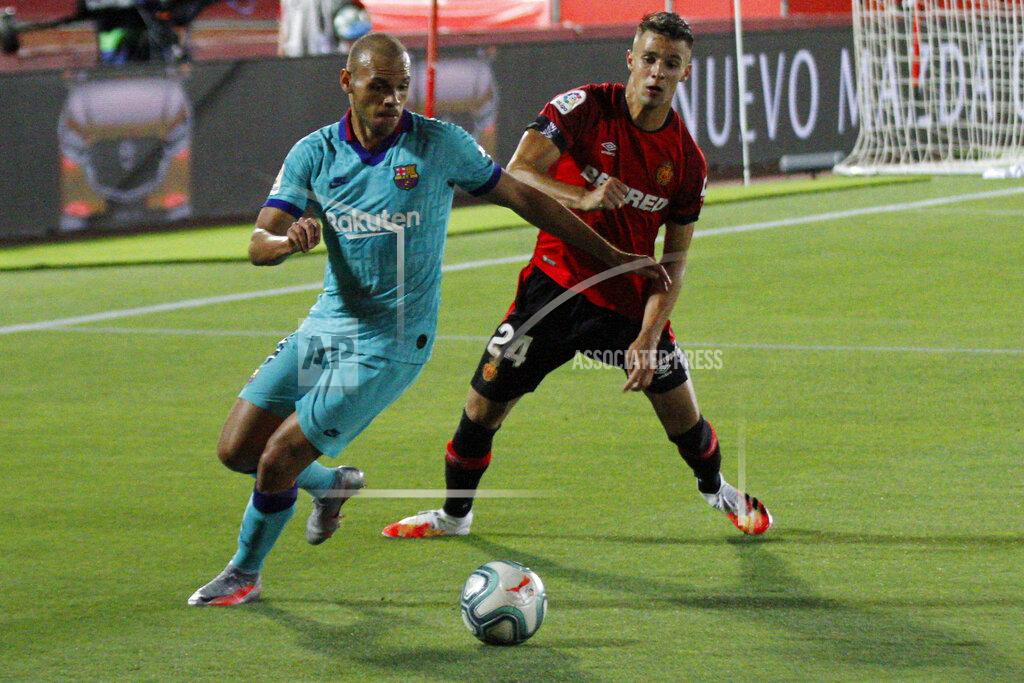 Francisco Ubilla FC Barcelona's Martin Braithwaite, left, vies for the ball with Marllorca's Martin Valjent, right, during the Spanish La Liga soccer match between Mallorca and FC Barcelona at Son Moix Stadium in Palma de Mallorca, Spain, Saturday, June 13, 2020. With virtual crowds, daily matches and lots of testing for the coronavirus, soccer is coming back to Spain. The Spanish league resumes this week more than three months after it was suspended because of the COVID-19 pandemic. (AP Photo/Francisco Ubilla)