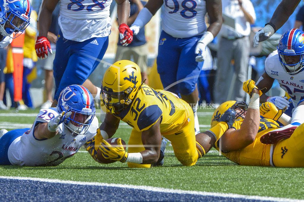 Craig Hudson West Virginia running back Martell Pettaway (32) recovers the football after fumbling during the first half of an NCAA college football game against Kansas in Morgantown, W. Va., Saturday Oct. 6, 2018. (AP Photo/Craig Hudson)