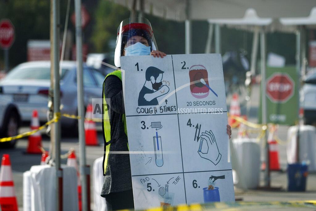 Marcio Jose Sanchez A worker gives instructions to motorists at a COVID-19 testing site Tuesday, Jan. 5, 2021, in Los Angeles. (AP Photo/Marcio Jose Sanchez)