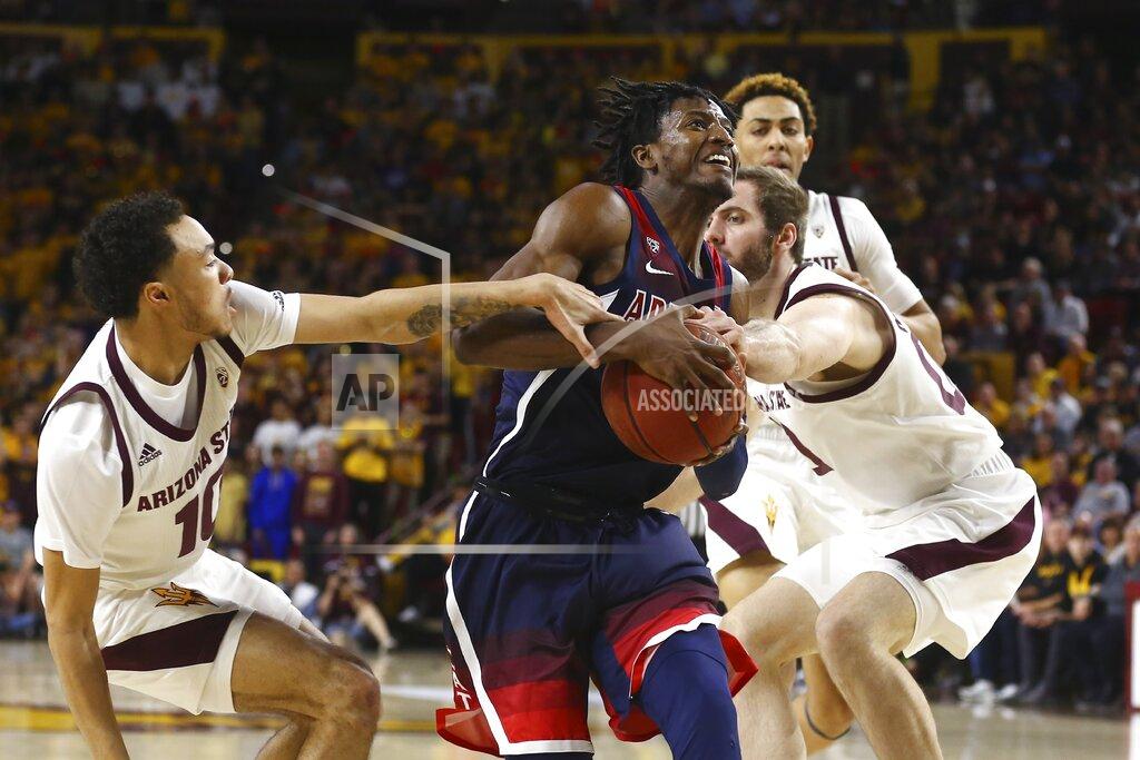 Ross D. Franklin Arizona guard Dylan Smith, middle, gets fouled as he gets past Arizona State guard Jaelen House (10), Arizona State forward Mickey Mitchell, right, as Arizona State forward Jalen Graham, back right, looks on during the first half of an NCAA college basketball game Saturday, Jan. 25, 2020, in Tempe, Ariz. (AP Photo/Ross D. Franklin)