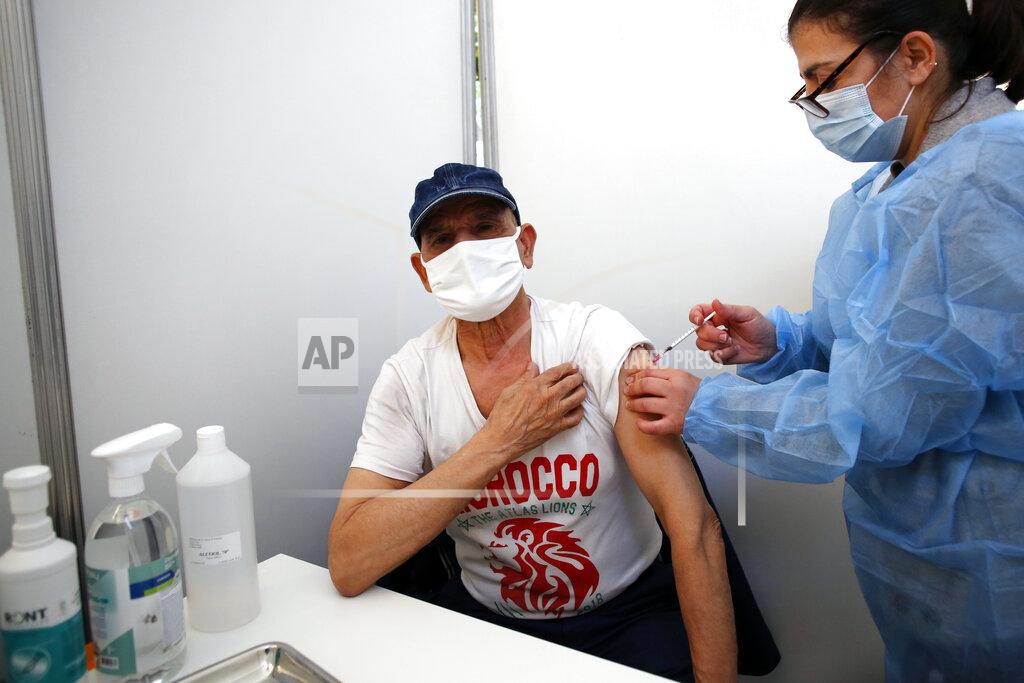 Uncredited FILE - In this Jan. 18, 2021, file photo, a man receives the Pfizer-BioNTech vaccination against COVID-19 at a vaccination center in Saint-Denis, north of Paris. Many people lining up for vaccines in the Paris suburb are particularly grateful for the injections. The surrounding region is the poorest in mainland France, with 130 languages spoken and the country's highest rise in mortality last spring. (AP Photo/Thibault Camus, File)