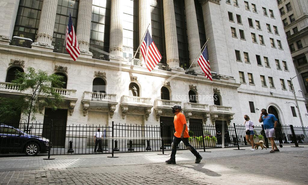 FILE- People walk by the New York Stock Exchange, Tuesday, July 21, 2020. Stocks are rising again on Wall Street, and the S&P 500 is ticking closer to its record high as it tries for a fourth straight gain. The S&P 500 was 0.6% higher after the first 30 minutes of Wednesday, Aug. 5, trading, following up on gains in European markets and across much of Asia. (AP Photo/Mark Lennihan)