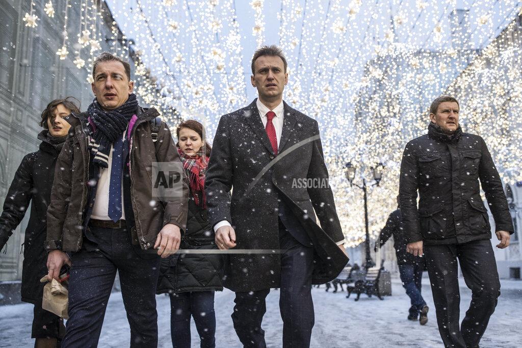 Evgeny Feldman FILE - In this file photo taken on Monday, Dec. 25, 2017, Russian opposition leader Alexei Navalny, who submitted endorsement papers necessary for his registration as a presidential candidate, center, heads to attend a meeting in the Russia's Central Election commission in Moscow, Russia. Russian opposition politician Alexei Navalny is in a coma and on a ventilator in an intensive care unit in Siberia after falling ill from suspected poisoning that his allies believe is linked to his political activity. (AP Photo/Evgeny Feldman)