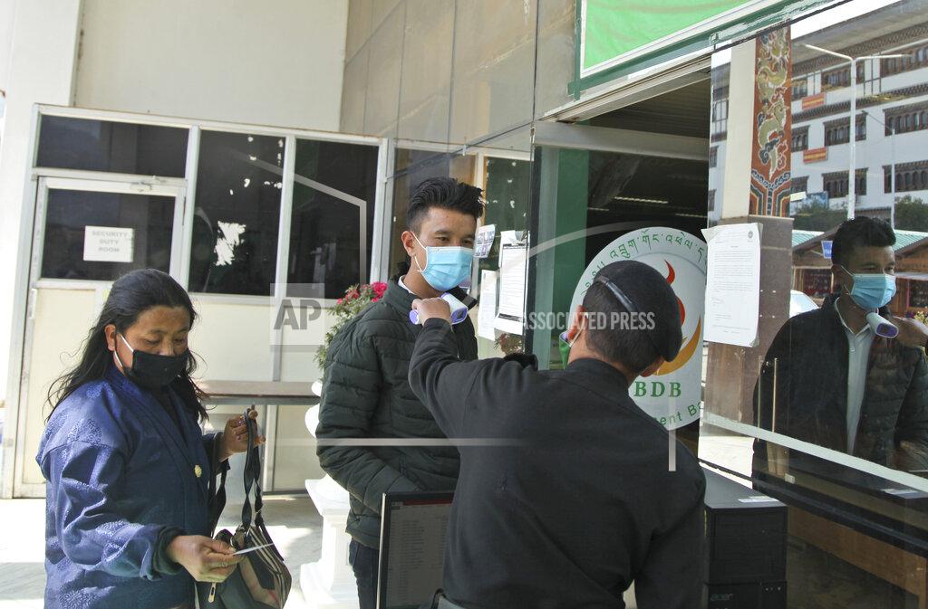 Uncredited A security official takes the temperature of people as a precaution against the coronavirus in Thimpu, Bhutan, Monday, April 12, 2021. The tiny Himalayan kingdom wedged between India and China has vaccinated nearly 93% of its adult population since March 27. Overall, the country has vaccinated 62% of its 800,000 people. (AP Photo)