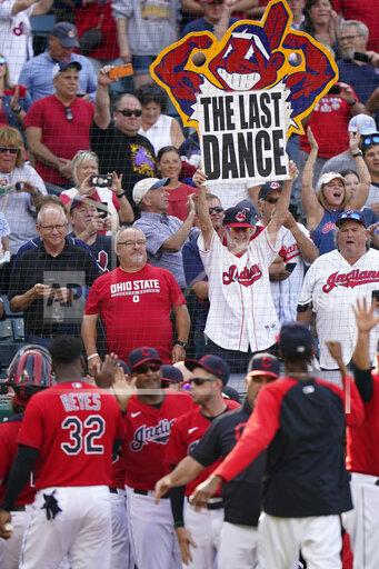 A Cleveland Indians fan holds up a sign as the team celebrates after defeating the Kansas City Royals in a baseball game, Monday, Sept. 27, 2021, in Cleveland. Cleveland played its final home game against the Royals as the Indians, the team's nickname since 1915. The club will be called the Cleveland Guardians next season. (AP Photo/Tony Dejak)
