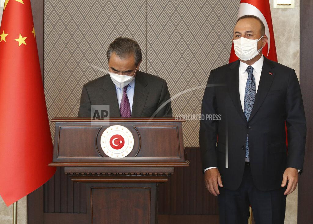 Uncredited Turkey's Foreign Minister Mevlut Cavusoglu, right, attends a joint news conference with China's Foreign Minister Wang Yi, left, following their meeting, in Ankara, Turkey, Thursday, March 25, 2021. Hundreds of members from the Uyghur community living in Turkey, staged protests in Istanbul and the capital Ankara, denouncing Wang Yi's visit to Turkey and demanding that the Turkish government take a stronger stance against human rights abuses in China's far-western Xinjiang region. (Turkish Foreign Ministry via AP, Pool)