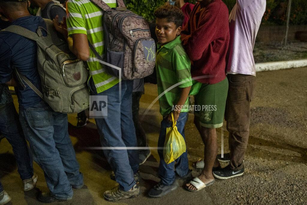 Moises Castillo Migrants from Honduras stand in line waiting for aid during their journey to the United States-Mexican border, in Morales, Guatemala, Thursday, Oct. 1, 2020. Honduran migrants hoping to reach the U.S. entered Guatemala on foot Thursday, testing the newly reopened frontier that had been shut due to the new coronavirus pandemic. (AP Photo/Moises Castillo)