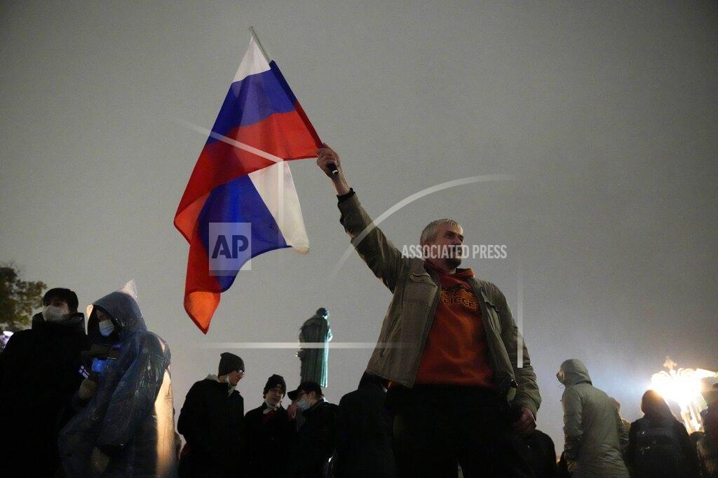 Pavel Golovkin A demonstrator holds a Russian national flag during a protest against the results of the Parliamentary election in Moscow, Russia, Monday, Sept. 20, 2021. The results in the other six regions that were allowed to vote online have been detailed. In Moscow, approval of the ruling party has always been particularly low and protest voting has been widespread. Candidates from the Communist Party called for demonstrations later in the day. (AP Photo/Pavel Golovkin)