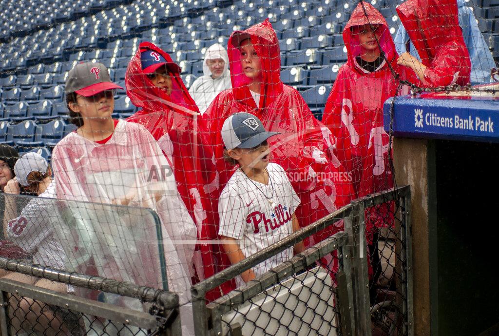 Laurence Kesterson Fans wait out a rain delay by the Philadelphia Phillies dugout after the second inning of a baseball game against the Washington Nationals, Sunday, Sept. 11, 2022, in Philadelphia. (AP Photo/Laurence Kesterson)