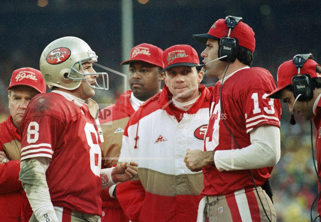 FILE - In this Jan. 18, 1993 file photo, San Francisco quarterbacks Steve Young, left, Joe Montana and Steve Bono, right; hold court along the sideline as time ran down in the Niners' 30-20 NFC championship loss to the Dallas Cowboys at Candlestick Park in San Francisco. Soon after the Super Bowl matchup was set, Hall of Famer Joe Montana went to Twitter to send out a picture of his framed jerseys for the Kansas City Chiefs and the San Francisco 49ers. Montana won four Super Bowl titles in 14 years with the 49ers before finishing his career with two seasons on the Chiefs when he made one trip to the AFC championship game. (AP Photo/Paul Sakuma, File)