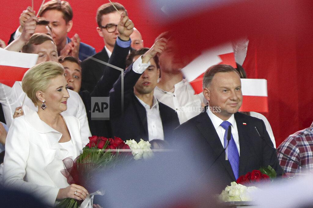 Czarek Sokolowski Incumbent President Andrzej Duda, right, smiles next to his wife Agata Kornhauser-Duda while addressing supporters in Pultusk, Poland, Sunday, July 12, 2020. Conservative Duda ran against liberal Warsaw Mayor Rafal Trzaskowski in a razor-blade-close presidential election runoff and exit poll shows election is too close to call. (AP Photo/Czarek Sokolowski)